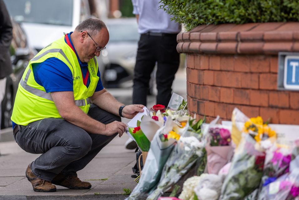 A man leaves flowers near the scene in Hart Street, Southport, where two children died and nine were injured in a ‘ferocious’ knife attack (James Speakman/PA)