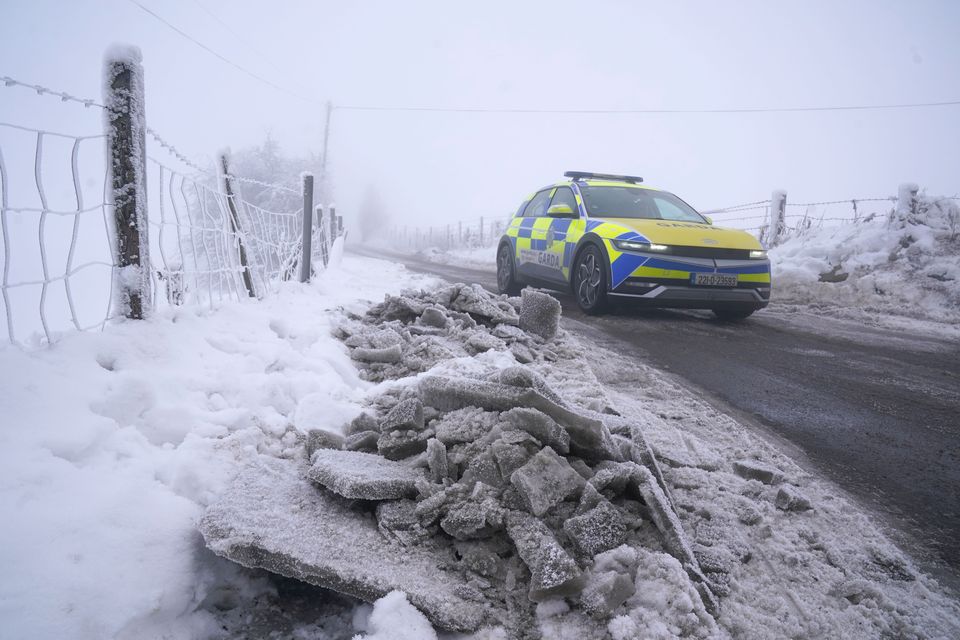 A Garda car passes cleared snow and ice on Slade More Road in Co. Dublin earlier this month (Brian Lawless/PA)