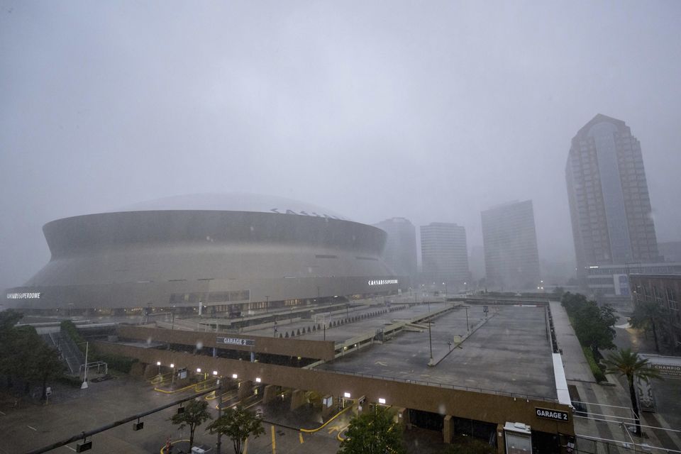 Rainfall from Hurricane Francine makes the white roof of the Caesars Superdome, left, difficult to see in New Orleans (Matthew Hinton/AP)