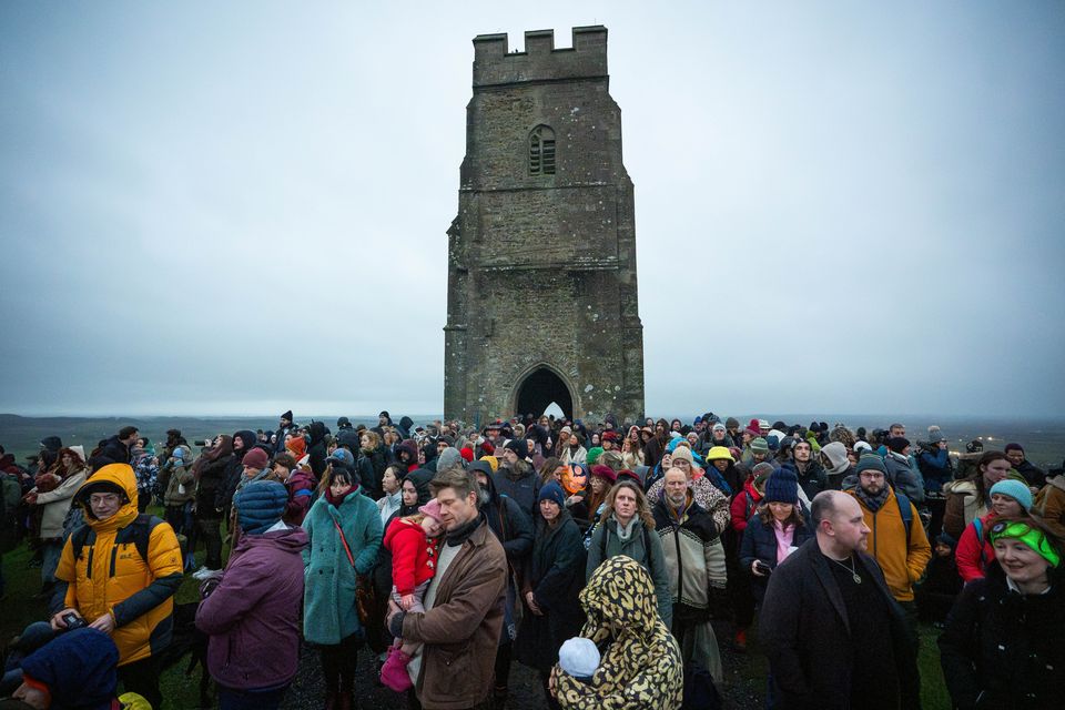 People take part in the winter solstice celebrations during sunrise at Glastonbury Tor (James Manning/PA)