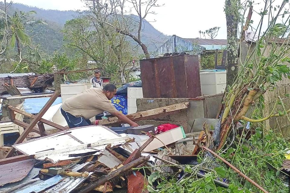 A resident recovers belongings from their damaged home caused by Typhoon Man-yi (MDRRMO Viga Catanduanes via AP)