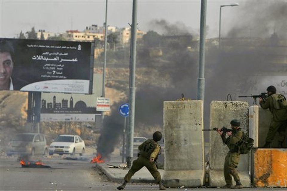 Israeli soldiers fire rubber bullets and throw stun grenades at Palestinian demonstrators during clashes following a demonstration against the Israeli missiles strike on Gaza, at the Kalandia checkpoint between the West Bank city of Ramallah and Jerusalem on Saturday, Dec. 27, 2008. Israeli warplanes retaliating for rocket fire from Gaza pounded dozens of security compounds across the Hamas-ruled territory in unprecedented waves of air strikes Saturday, killing at least 155 and wounding more than 310 in the bloodiest day in Gaza in decades. (AP Photo/Muhammed Muheisen)