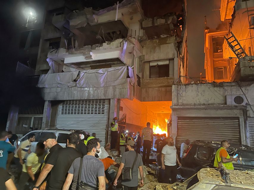 People gather in front of a destroyed building hit by an Israeli airstrike in central Beirut. Photo: AP