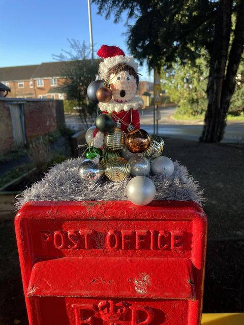 Pat the topper elf wrapped in Christmas decorations (Brough Yarn Bombers/PA)