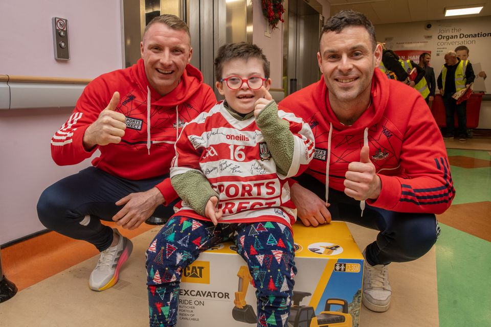 Harry Bassel, seven, with Cork senior footballers Brian Hurley (left) and Michael Aodh Martin (right) (Colm Lougheed/PA)