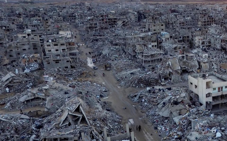 An aerial photograph taken by a drone shows Palestinians walking through the destruction caused by the Israeli air and ground offensive in Rafah (AP/Jehad Alshrafi)