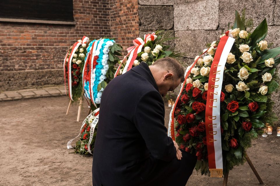 Polish president Andrzej Duda kneels in front of the Death Wall (Oded Balilty/AP)