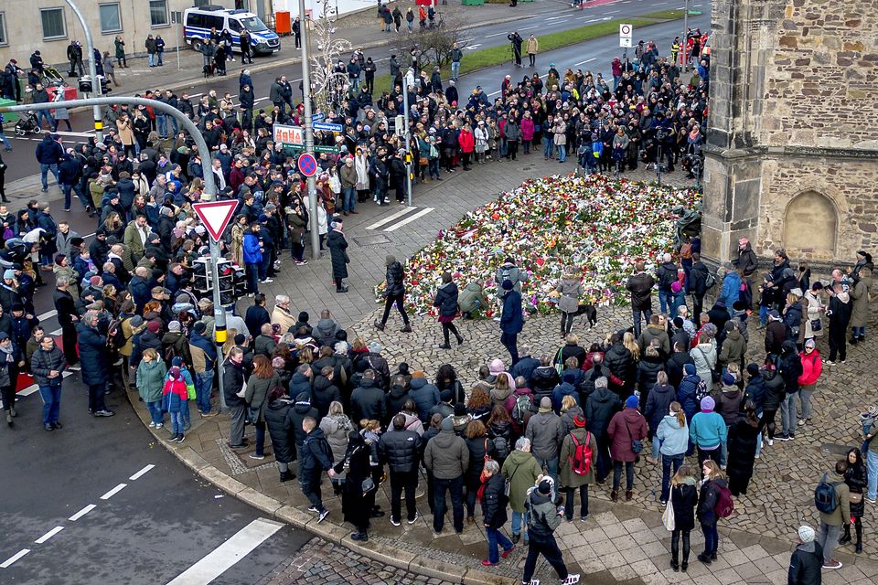 People have gathered to lay flowers and light candles at the entrance of the Johannis church near the scene of the deadly attack (Michael Probst/AP)