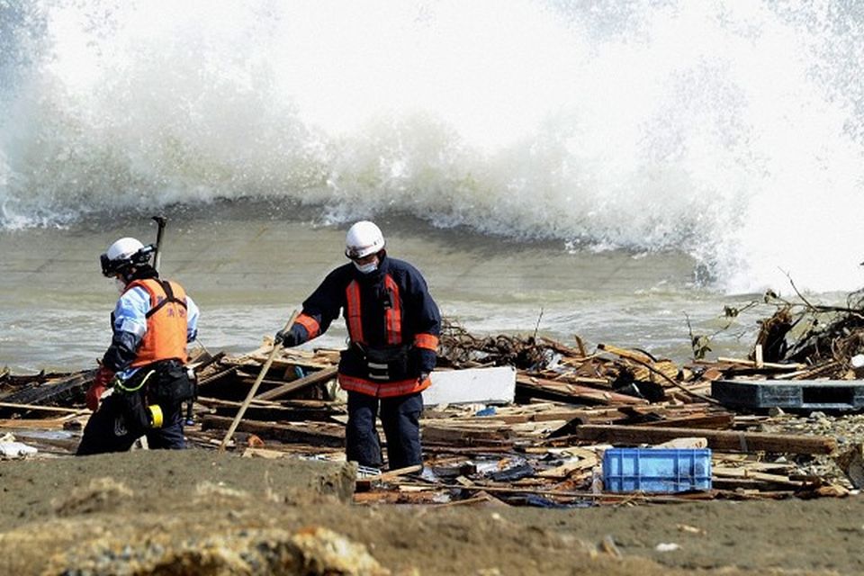 Rescue workers search for quake and tsunami victims at a beach in Kesennuma, northeastern Japan (AP)