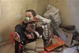thumbnail: Fares al-Dali drinks tea as he sits on a pile of wood and cartons in a house in the Shati refugee camp in Gaza City, Monday, Jan. 12, 2009. In the al-Dali family's two-room shack in the Shati refugee camp, 21 people _ half of them relatives who fled the fighting _ take turns sleeping because the family doesn't have enough mattresses. For lack of fuel, they cook on trash fires _ paper and cartons collected in the neighborhood. (AP Photo/Adel Hana)