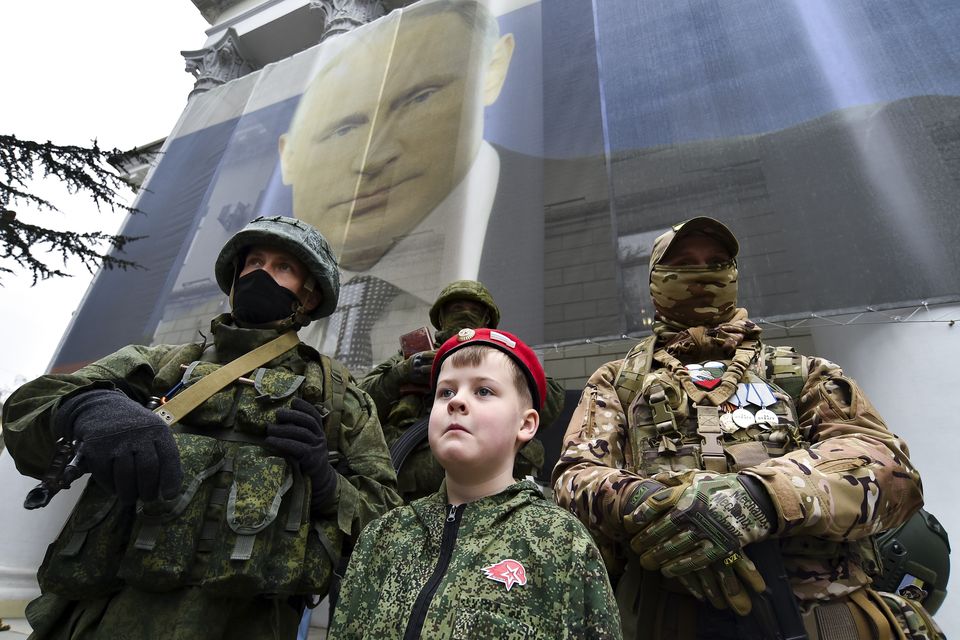 A boy and Russian soldiers take part in an event to mark the ninth anniversary of the Crimea annexation from Ukraine in Yalta, Crimea (AP)