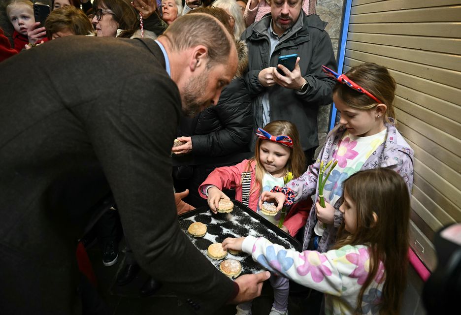 Children help themselves to some of William’s cakes (Ben Stansall/PA)