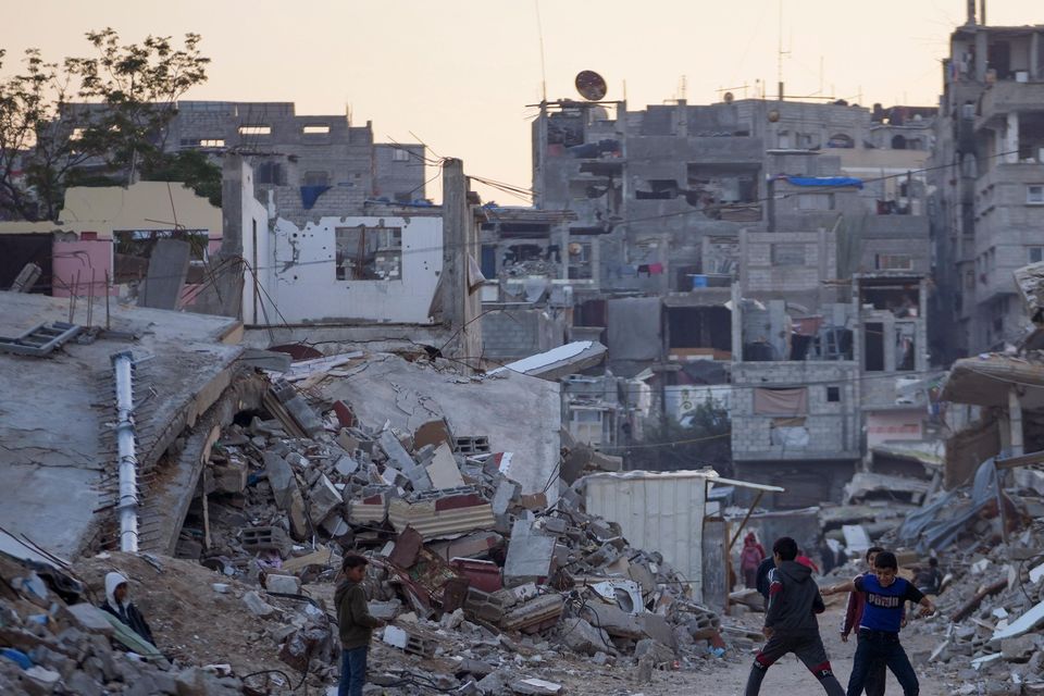 Palestinian children play next to buildings destroyed by Israeli army strikes in Khan Younis (Abdel Kareem Hana/AP)