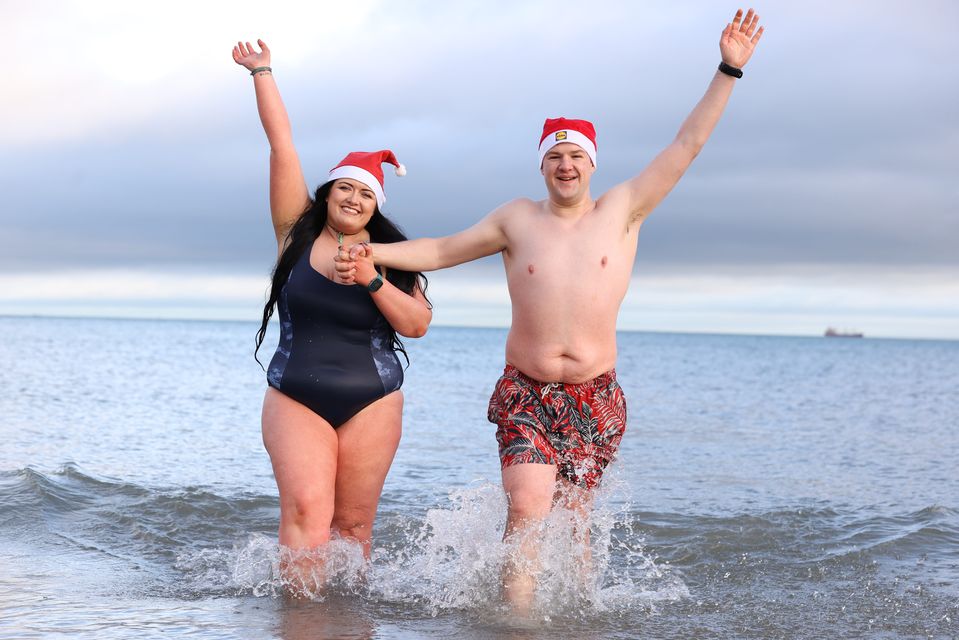 Rebecca Browne and Joel McElwee take part in the annual Christmas Eve swim at Helen’s Bay, Co Down, in aid of local charities (Liam McBurney/PA)