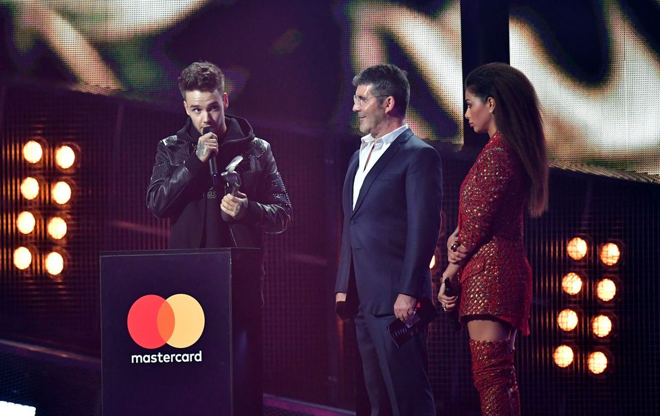 Nicole Scherzinger and Simon Cowell look on as Liam Payne collects his award for One Direction on stage at the Brit Awards (Dominic Lipinski/PA)