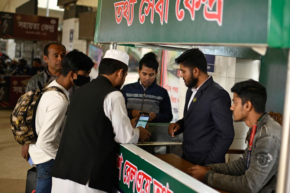 Stranded passengers make inquiries with a railway official amid the nationwide strike (Mahmud Hossain Opu/AP)