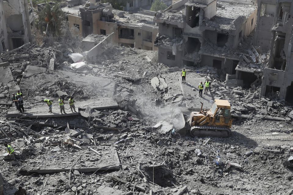 Rescue workers use a bulldozer to remove the rubble of destroyed buildings at the site that was hit by Israeli air strikes in Qana (Mohammed Zaatari/AP)