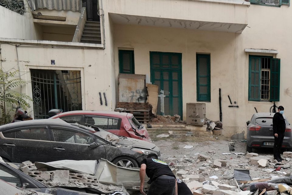 People search through the rubble of a destroyed building at the site of an Israeli air strike in central Beirut (Bilal Hussein/AP)