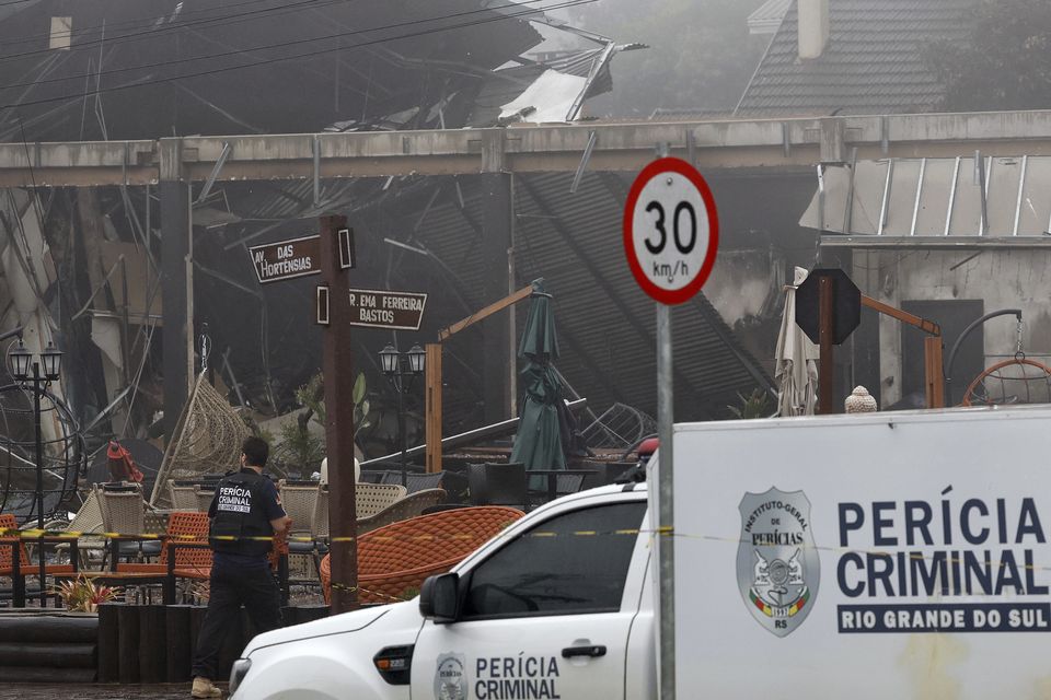 Police carry out an investigation outside houses that were hit by a plane in Gramado, Rio Grande do Sul State, Brazil (Mateus Bruxel, Agencia RBS/AP)