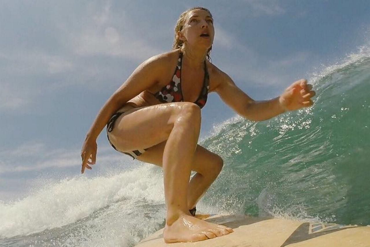 Emma Vardy in wetsuit surfing