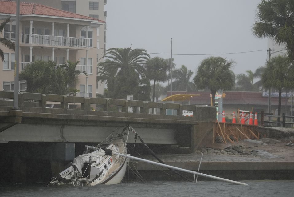 A boat damaged in Hurricane Helene rests against a bridge ahead of the arrival of Hurricane Milton in South Pasadena, Florida (Rebecca Blackwell/AP)