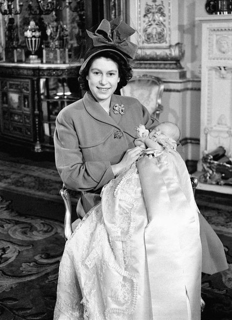 Princess Elizabeth holds her one-month-old baby son, Prince Charles, after his christening ceremony at Buckingham Palace in 1948 (PA)