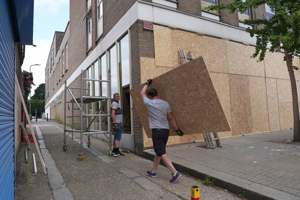 Workers were seen boarding up shop fronts in North Finchley, London, on Wednesday afternoon (Jordan Pettitt/PA)