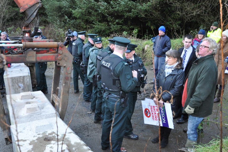 Police line up while concrete blocks are placed at the site during the protest over the drilling