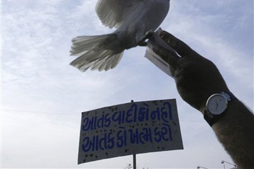 An Indian Muslim, only hand seen, releases a pigeon during a protest against terrorist attacks in Mumbai, as a placard reads " Kill terror not terrorist " in Ahmadabad, India, Saturday, Nov. 29, 2008. Indian commandos killed the last remaining gunmen holed up at a luxury Mumbai hotel Saturday, ending a 60-hour rampage through India's financial capital by suspected Islamic militants that killed people and rocked the nation. (AP Photo/Ajit Solanki)