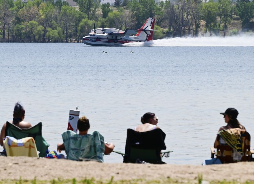 A firefighting aircraft scoops water off a reservoir to then drop over the nearby Quarry Fire in Colorado (Andy Cross/The Denver Post/AP)