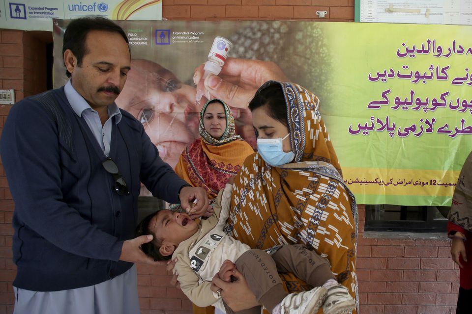 A health worker administers a polio vaccine to a child at a health centre in Peshawar, Pakistan (Muhammad Sajjad/AP)