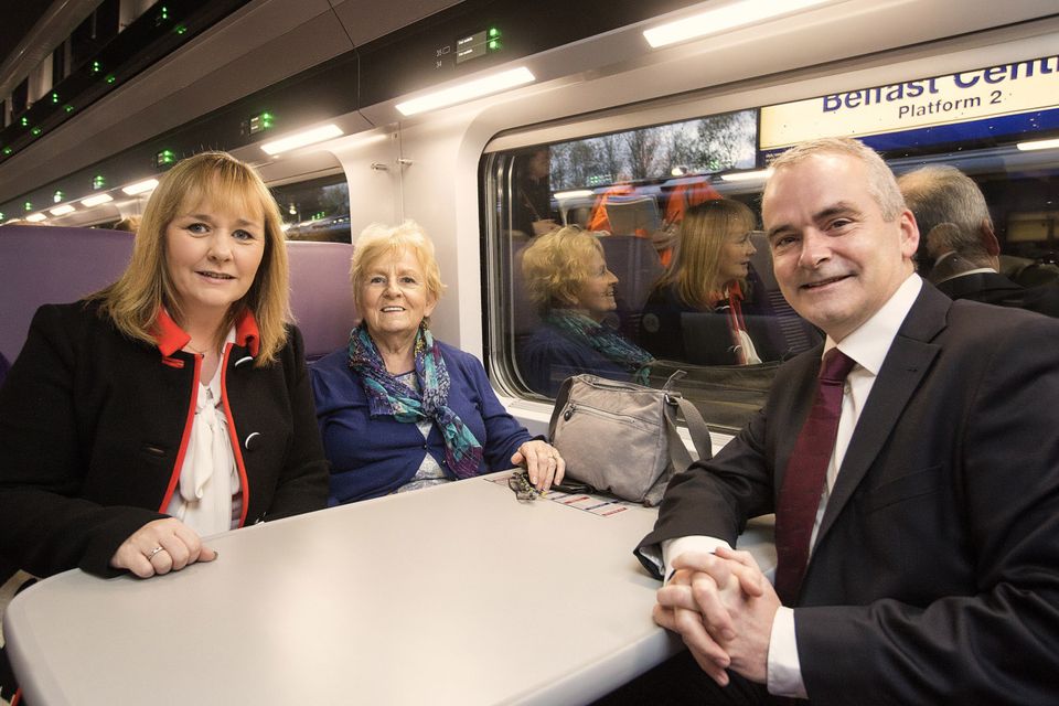Chris Conway, group chief executive for Translink, and Regional Development Minister Michelle McIlveen with customer Edna Murray, from Belfast, on a newly refurbished Enterprise train leaving Belfast