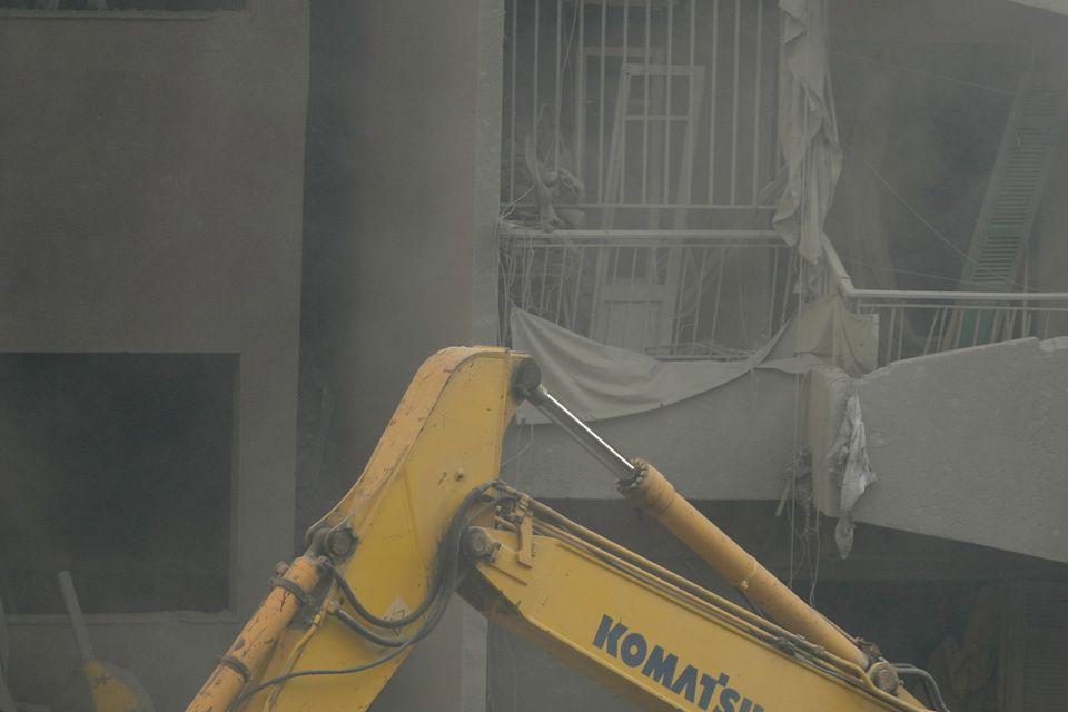 Rescue workers digging through rubble at the site of the air strike in central Beirut (AP Photo/Hassan Ammar)