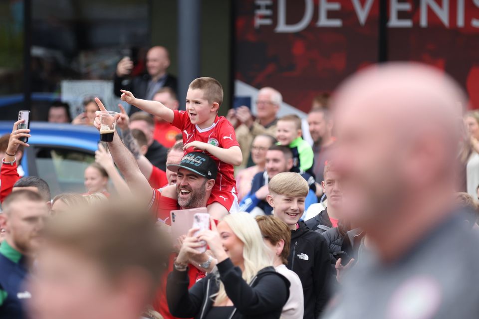 Clifonville fans wait to catch a glimpse of Irish Cup winners Cliftonville Football players as they arrive at the Devinish bar on an open top bus to meets supporters.  Picture by Peter Morrison