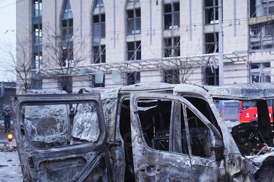 A destroyed car is seen as firefighters work on the site of a damaged building (Efrem Lukatsky/AP)