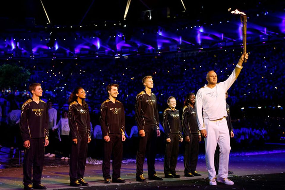 Steve Redgrave, right, holds the Olympic torch after entering the stadium during the Opening Ceremony at  the 2012 Summer Olympics, Saturday, July 28, 2012, in London. (AP Photo/Matt Dunham, Pool)