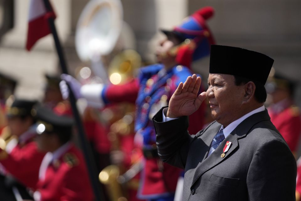 Indonesian President Prabowo Subianto salutes the honour guard during a welcoming ceremony at the government palace in Lima, Peru (AP Photo/Fernando Vergara)