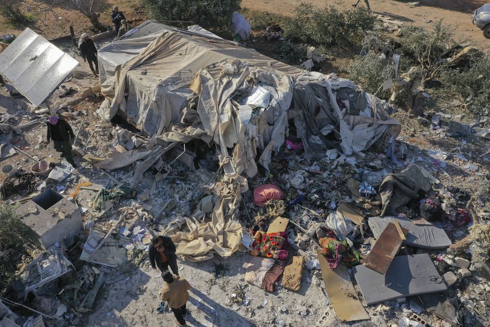 People inspect a camp for the internally displaced after an air strike near the village of Harbnush, north of Idlib, Syria (Ghaith Alsayed/AP)