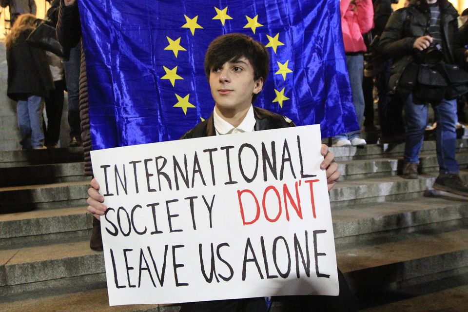 A man holds a poster during the opposition protest against the results of the parliamentary election in Tbilisi, Georgia (Shakh Aivazov/AP)