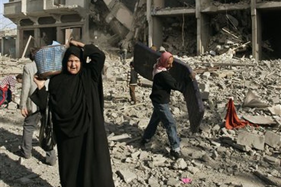 Palestinians salvage belongings from an apartment building following an Israeli airstrike in Gaza City, Tuesday, Jan.13, 2009.Israeli troops advanced into Gaza suburbs for the first time early Tuesday, residents said, hours after Prime Minister Ehud Olmert warned Islamic militants that they face an "iron fist" unless they agree to Israeli terms for an end to war in the Gaza Strip.(AP Photo/Hatem Moussa)