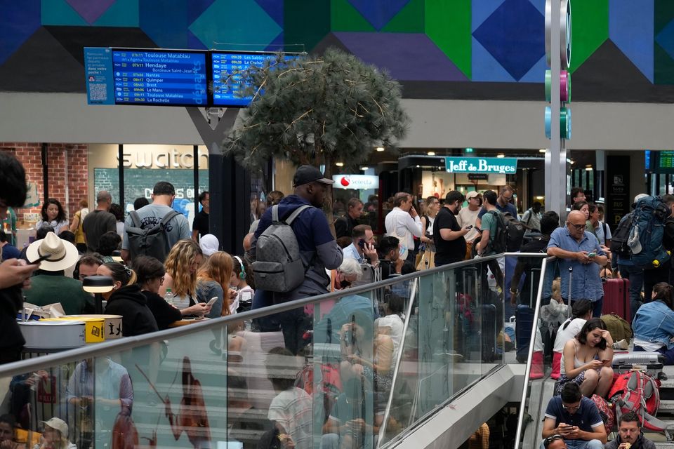 Passengers sit on stairs at the Gare de Montparnasse in Paris (Yasin Dar/AP)