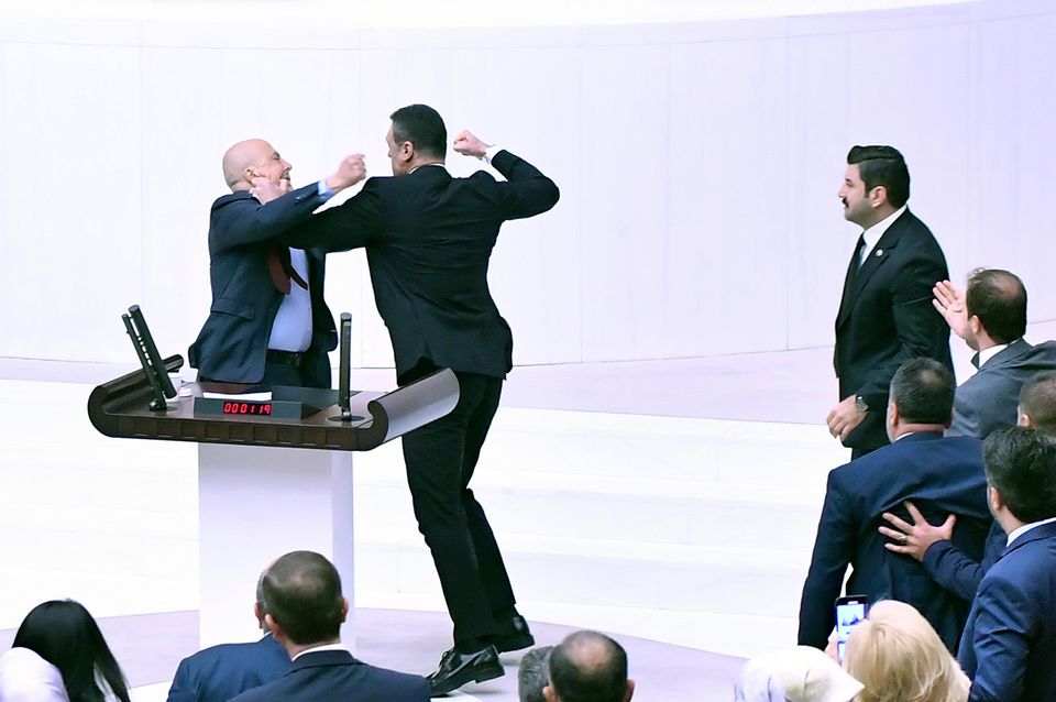 Turkey’s AK Party MP Alpay Ozalan, second left, scuffles with Workers’ Party of Turkey MP Ahmet Sik ((DIA Images/AP)