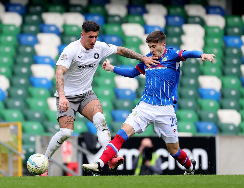 Carrick Rangers striker Danny Gibson bids to retain possession under pressure from Linfield's Josh Archer