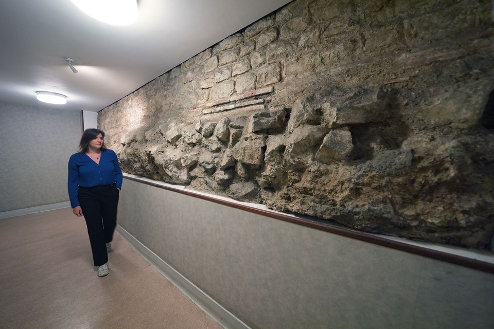 PA court reporter Emily Pennink views a section of the old Roman Wall which encircles the City of London and is among the foundations of the Old Bailey (Yui Mok/PA)