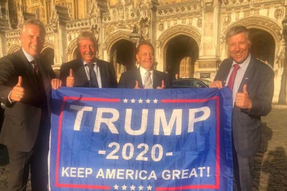 Banner drama: Ian Paisley (left), Sammy Wilson (second left) and Paul Girvan (right) with the Trump flag