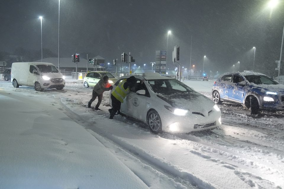 People help to push cars stuck in snow in Leeds (Danny Lawson/PA)