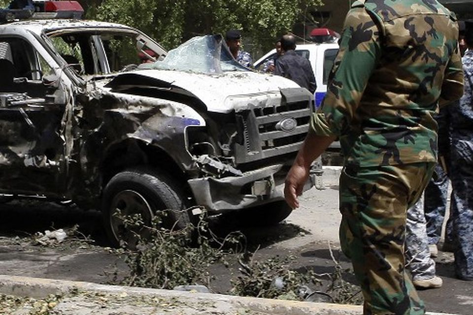Security forces inspect the scene of a car bomb attack in Karradah in Baghdad, Iraq (AP)