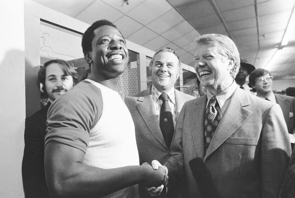 Then-Georgia governor Jimmy Carter, right, and Delaware governor Sherman Tribbitt say hello to Atlanta Braves Hank Aaron, left (Anonymous/AP)