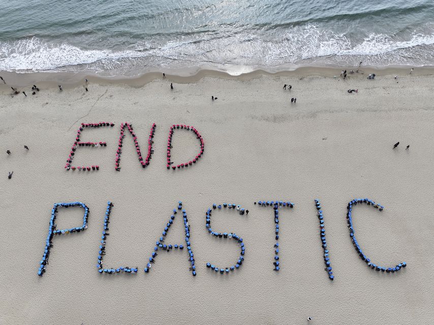 Environment activists perform a human sign calling for a strong global plastics treaty ahead of the fifth session of the Intergovernmental Negotiating Committee on Plastic Pollution (Son Hyung-joo/Yonhap via AP)