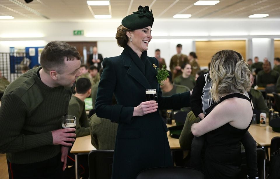 Kate with Barry Loughlin, Georgia Willis and four-year-old Regan Loughlin, as she joins guardsmen and their families in the junior ranks dining hall (Eddie Mulholland/Daily Telegraph/PA)